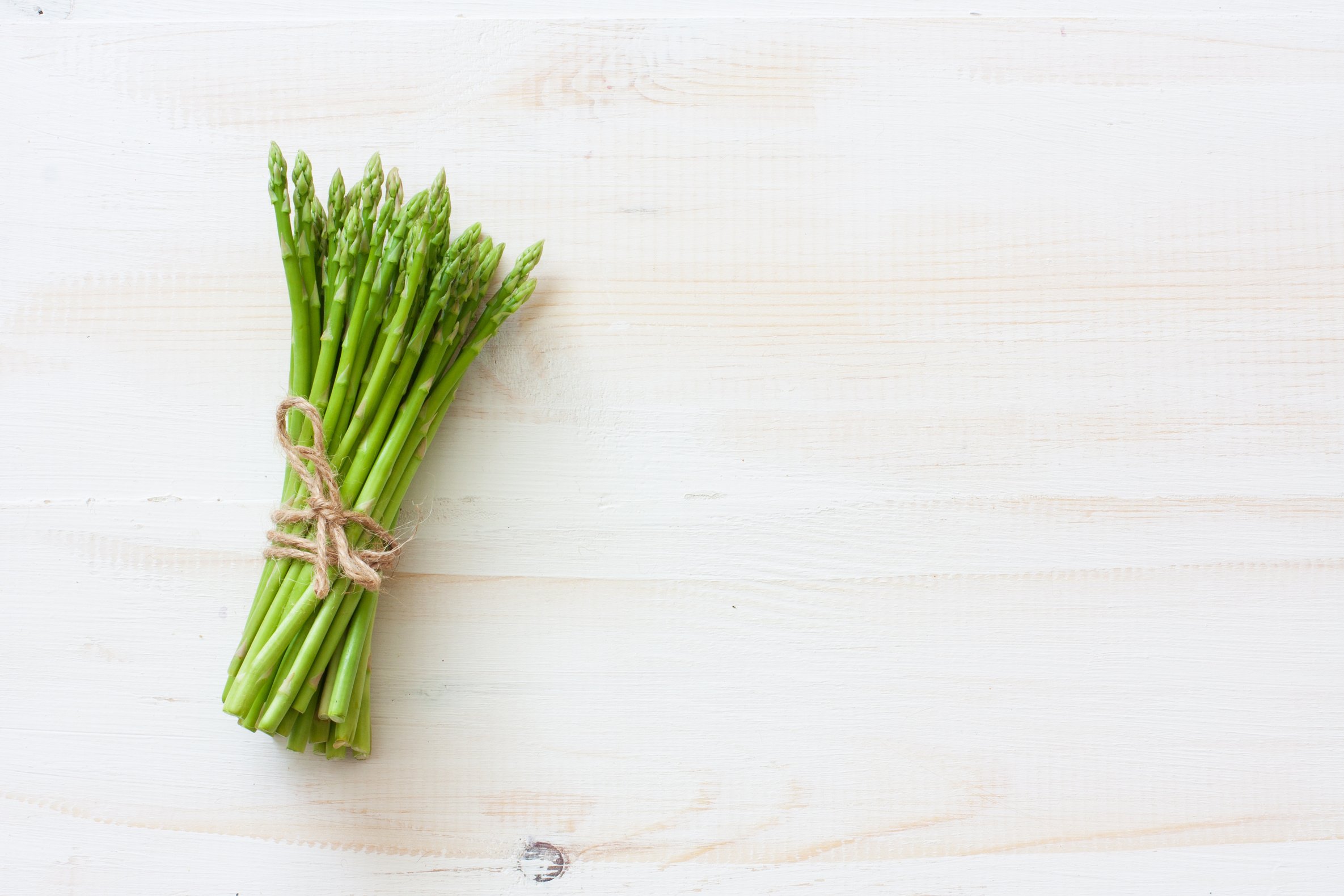 Fresh asparagus on white wood background